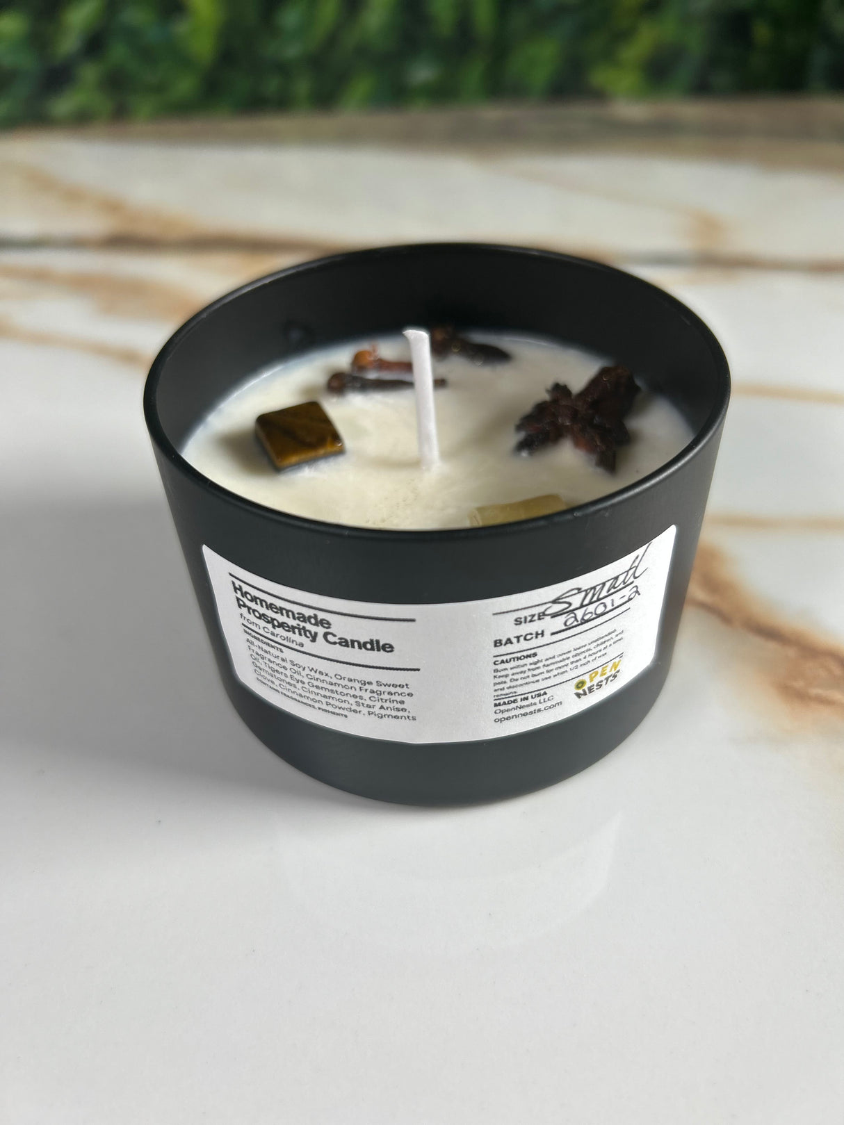 Candle in a black small tin container with a label