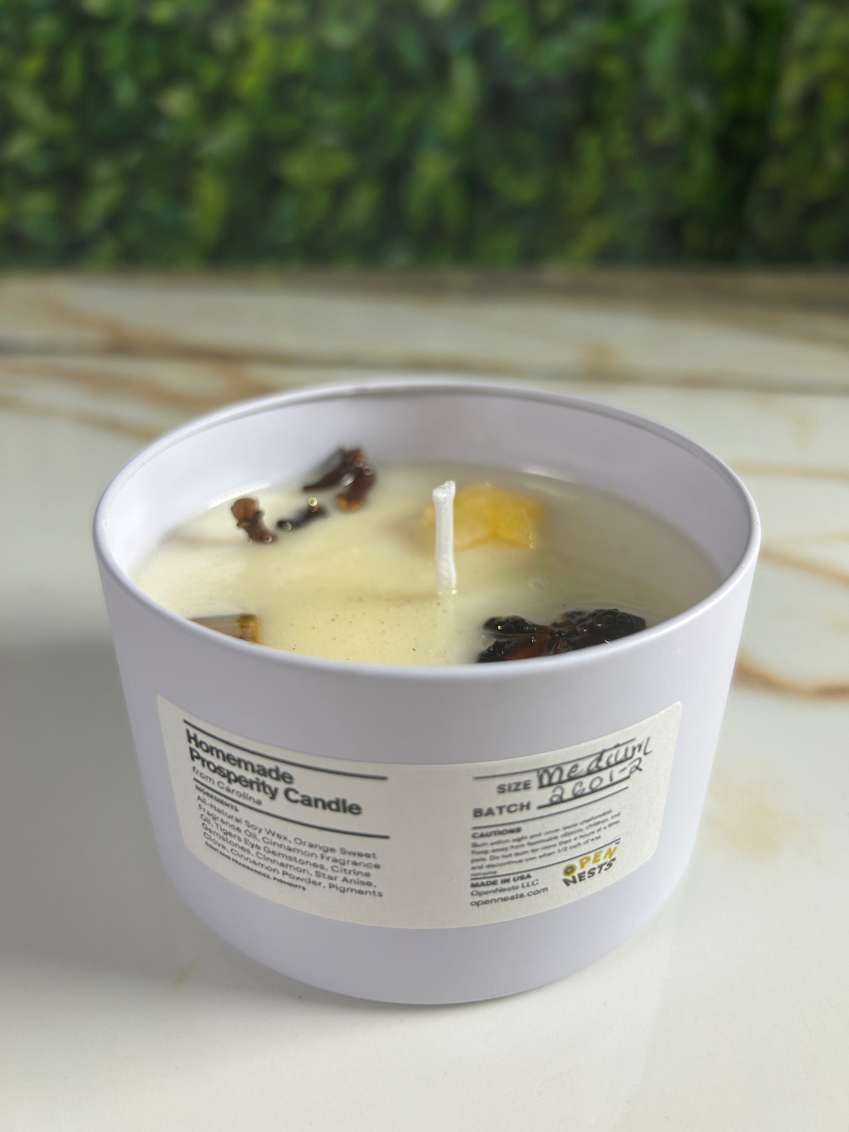 Candle in a medium white tin container with a label 